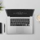 na biurku laptop,, kawa, notes i kwiatek zielony